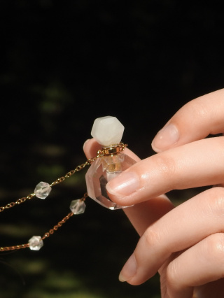 Długi wisiorek z odkręcaną perfumetką z kryształu górskiego i mniejszymi kryształami z pozłacanej stali chirurgicznej